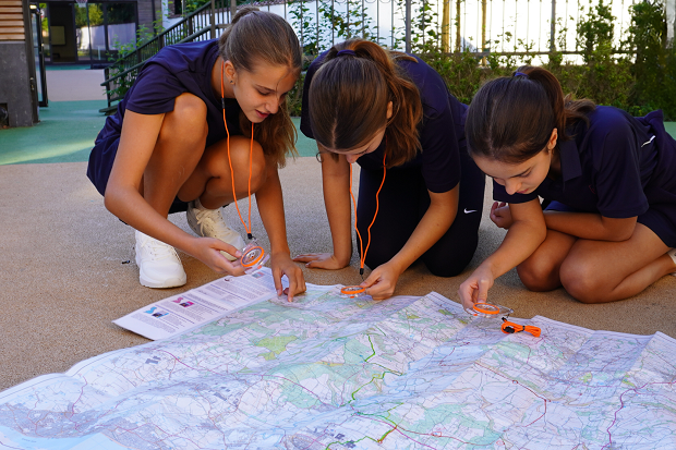BJAB students learning map reading and navigation outdoors with compasses